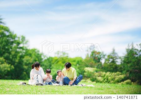 A family of four having a picnic on a sunny hill. A family of four having a picnic on a sunny hill. 140741871