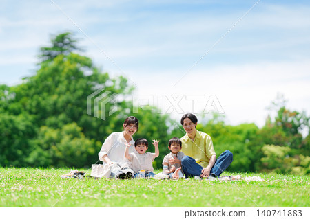 A family of four having a picnic on a sunny hill. 140741883