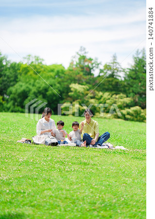 A family of four having a picnic on a sunny hill. A family of four having a picnic on a sunny hill. 140741884