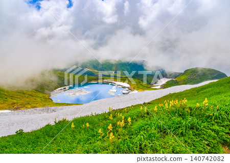 On a clear summer day, snowdrifts adorn the mystical crater lake, Lake Chokai, on Mount Chokai, creating a beautiful reflection of the summer sky. On a clear summer day, snowdrifts adorn the mystical crater lake, Lake Chokai, on Mount Chokai, creating a beautiful reflection of the summer sky. 140742082