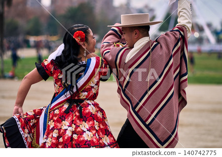 A pair of young Chilean Latin dancers dancing cuecas, the Chilean national dance, in a very cheerful, charismatic, and romantic manner. Chilean Independence Day A pair of young Chilean Latin dancers dancing cuecas, the Chilean national dance, in a very cheerful, charismatic, and romantic manner. Chilean Independence Day 140742775