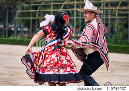 A pair of young Chilean Latin dancers dancing cuecas, the Chilean national dance, in a very cheerful, charismatic, and romantic manner. Chilean Independence Day  140742787
