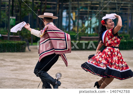 A pair of young Chilean Latin dancers dancing cuecas, the Chilean national dance, in a very cheerful, charismatic, and romantic manner. Chilean Independence Day  140742788