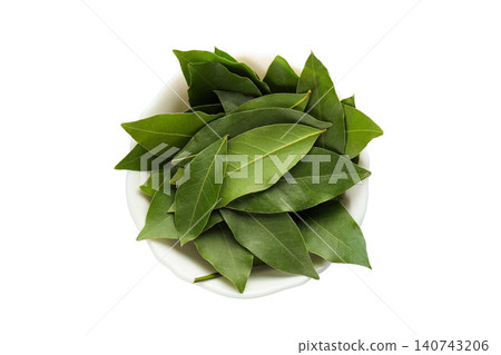 Fresh bay leaves are neatly placed in a bowl for culinary preparation, PNG 140743206