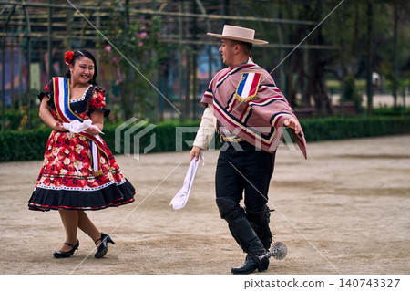 Portrait of a smiling young couple dressed as Chilean huasos, joyfully dancing Portrait of a smiling young couple dressed as Chilean huasos, joyfully dancing 140743327