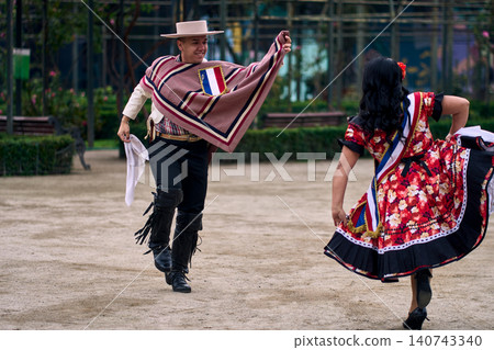 Portrait of a smiling young couple dressed as Chilean huasos, joyfully dancing Portrait of a smiling young couple dressed as Chilean huasos, joyfully dancing 140743340