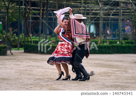 Portrait of a smiling young couple dressed as Chilean huasos, joyfully dancing Portrait of a smiling young couple dressed as Chilean huasos, joyfully dancing 140743341