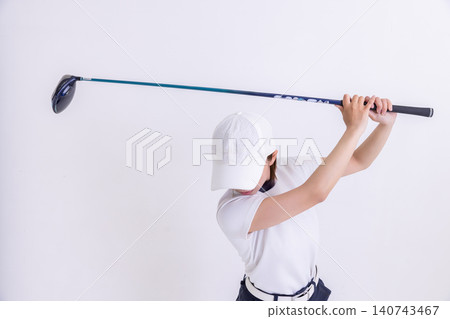 Female golfer taking a driver swing Female golfer taking a driver swing 140743467