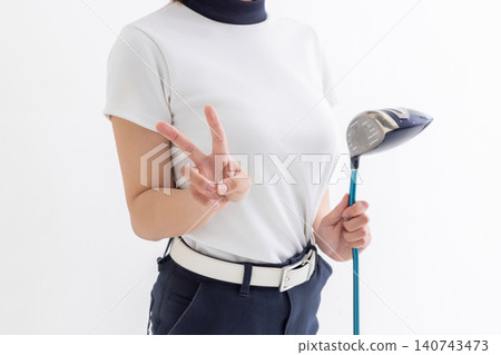 A female golfer makes a V-sign against a white background. A female golfer makes a V-sign against a white background. 140743473