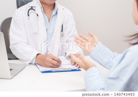 Doctor and patient having a medical consultation in a hospital room, explaining a treatment plan, discussing diagnosis, and giving advice during a medical health checkup appointment in a clinic 140743493