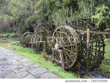 Wooden water wheel system on a stream in Yellow Dragon Park in the mountains near Zhangjiajie, China 140743694