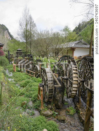 Wooden water wheel system on a stream in Yellow Dragon Park in the mountains near Zhangjiajie, China 140743697