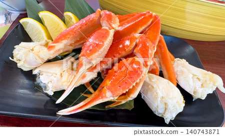 Crab served on a plate; boiled crab legs and claws served on a large plate in a Japanese dish. 140743871