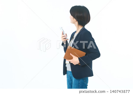一個人背對著觀眾,手持智慧型手機和棕色資料夾,背景為白色。 一個人背對著觀眾,手持智慧型手機和棕色資料夾,背景為白色。 140743877