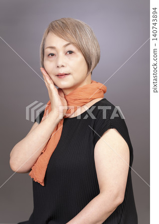 Studio portrait photography of a senior woman, gray background. 140743894
