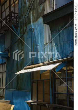 Blue corrugated iron wall with light shining in from above Blue corrugated iron wall with light shining in from above 140744580