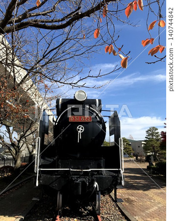 Front view of the JNR Class D51 steam locomotive No. 822, which is preserved in a static display in front of Mattō Station, and autumn foliage. Front view of the JNR Class D51 steam locomotive No. 822, which is preserved in a static display in front of Mattō Station, and autumn foliage. 140744842