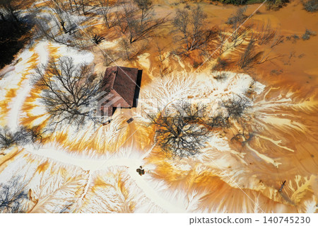 Sinking house in the ghost village of Geamana, Romania, choked of toxic mining residuals, aerial view Sinking house in the ghost village of Geamana, Romania, choked of toxic mining residuals, aerial view 140745230