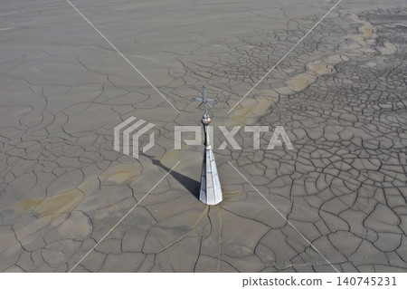 Aerial view of a sinking church in a decanting lake, tower with cross raising over mud Aerial view of a sinking church in a decanting lake, tower with cross raising over mud 140745231