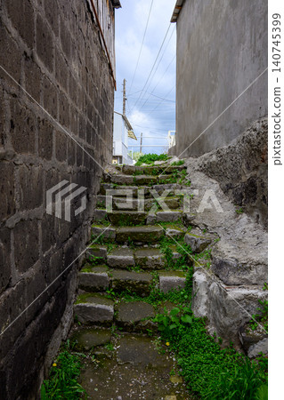 Old stone staircase between weathered walls Old stone staircase between weathered walls 140745399