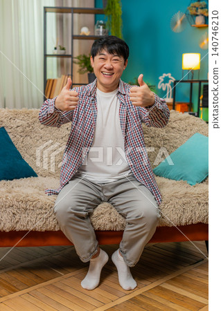Asian man giving double thumbs up, positive like gesture showing approval and enthusiastic agreement Asian man giving double thumbs up, positive like gesture showing approval and enthusiastic agreement 140746210