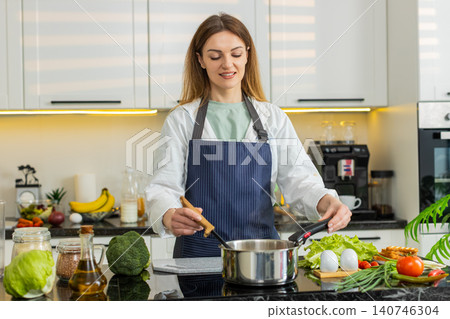 Middle-aged woman stirring homemade soup in home kitchen smelling aroma for healthy diet nutrition 140746304
