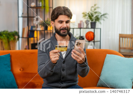 Indian man completes online purchase with smartphone enters cvv payment approved satisfied smile yay Indian man completes online purchase with smartphone enters cvv payment approved satisfied smile yay 140746317