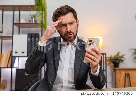Middle-aged businessman frustrated reading client rejection on smartphone frowns at news loses game Middle-aged businessman frustrated reading client rejection on smartphone frowns at news loses game 140746366