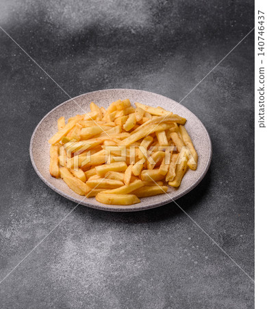 Golden French fries fried with salt and spices, unhealthy takeaway food. French fries Golden French fries fried with salt and spices, unhealthy takeaway food. French fries 140746437