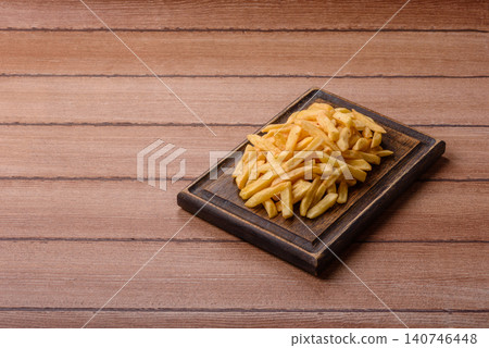 Golden French fries fried with salt and spices, unhealthy takeaway food. French fries Golden French fries fried with salt and spices, unhealthy takeaway food. French fries 140746448