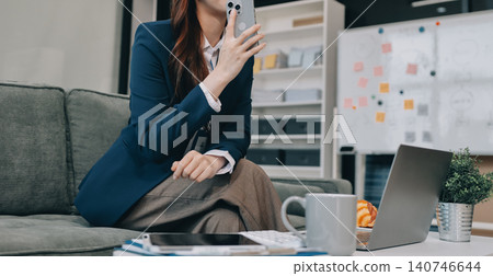 Young asian businesswoman talking on phone and using digital tablet at work Young asian businesswoman talking on phone and using digital tablet at work 140746644