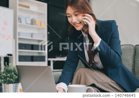 Young asian businesswoman talking on phone and using digital tablet at work Young asian businesswoman talking on phone and using digital tablet at work 140746645