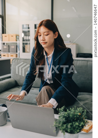 Asian businesswoman sitting at work using laptop talking and consulting in office 140746647