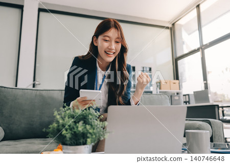 Asian businesswoman sitting at work using laptop talking and consulting in office 140746648