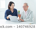 An elderly man learning to use a computer and his daughter teaching him. 140746928