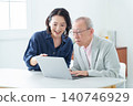 An elderly man learning to use a computer and his daughter teaching him. 140746929