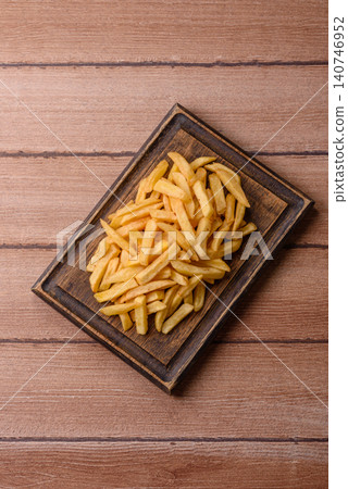 Golden French fries fried with salt and spices, unhealthy takeaway food. French fries Golden French fries fried with salt and spices, unhealthy takeaway food. French fries 140746952