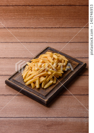 Golden French fries fried with salt and spices, unhealthy takeaway food. French fries Golden French fries fried with salt and spices, unhealthy takeaway food. French fries 140746953