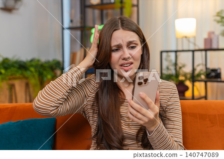 Young woman checks smartphone sees game loss sighs feels upset frowns after failed bet and bad news Young woman checks smartphone sees game loss sighs feels upset frowns after failed bet and bad news 140747089