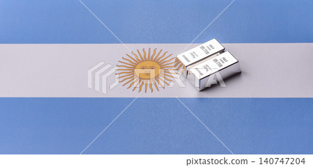 A silver bar, white metal against a backdrop of Argentine money, as a concept for the sales market A silver bar, white metal against a backdrop of Argentine money, as a concept for the sales market 140747204