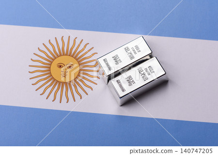 A silver bar, white metal against a backdrop of Argentine money, as a concept for the sales market 140747205