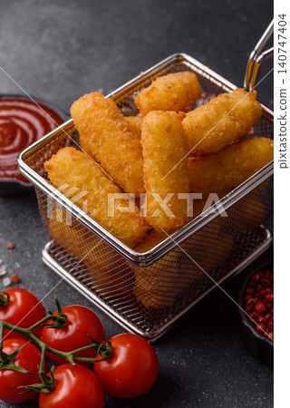 Mozzarella cheese sticks, breaded and fried with salt and tomato sauce, for takeaway. Cheese sticks Mozzarella cheese sticks, breaded and fried with salt and tomato sauce, for takeaway. Cheese sticks 140747404