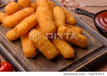 Mozzarella cheese sticks, breaded and fried with salt and tomato sauce, for takeaway. Cheese sticks Mozzarella cheese sticks, breaded and fried with salt and tomato sauce, for takeaway. Cheese sticks 140747415