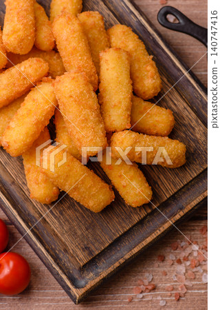 Mozzarella cheese sticks, breaded and fried with salt and tomato sauce, for takeaway. Cheese sticks 140747416