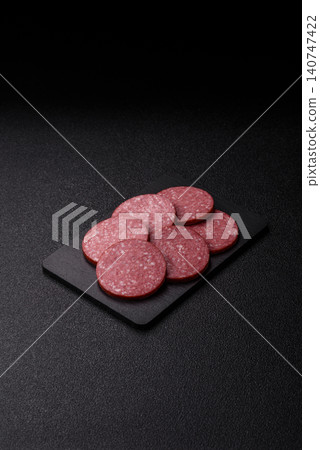 Slices of smoked salami or pepperoni for making sandwiches or pizza at home. Sausage slices 140747422