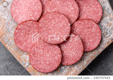 Slices of smoked salami or pepperoni for making sandwiches or pizza at home. Sausage slices 140747443