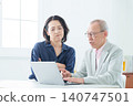 An elderly man using a computer with a troubled expression. 140747501