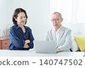 An elderly man using a computer with a troubled expression. 140747502