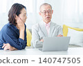 An elderly man using a computer with a troubled expression. 140747505