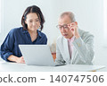 An elderly man using a computer with a troubled expression. 140747506